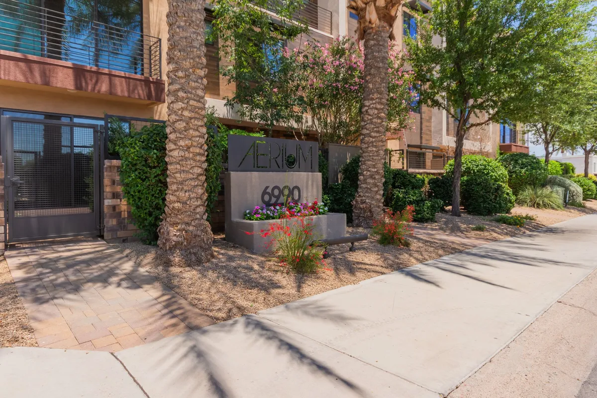 The entrance gate and property sign, set against landscaped greenery, create a sense of arrival and exclusivity. The inviting mood and clear signage make it easy for guests to identify and access the property, while the outdoor setting connects the location to its surroundings.